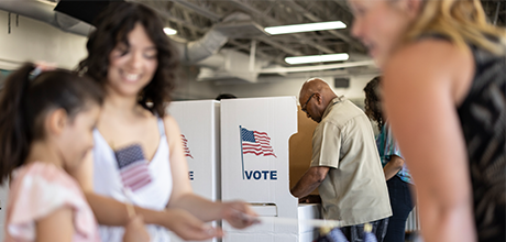 Woman and daughter turning their vote in at a polling location